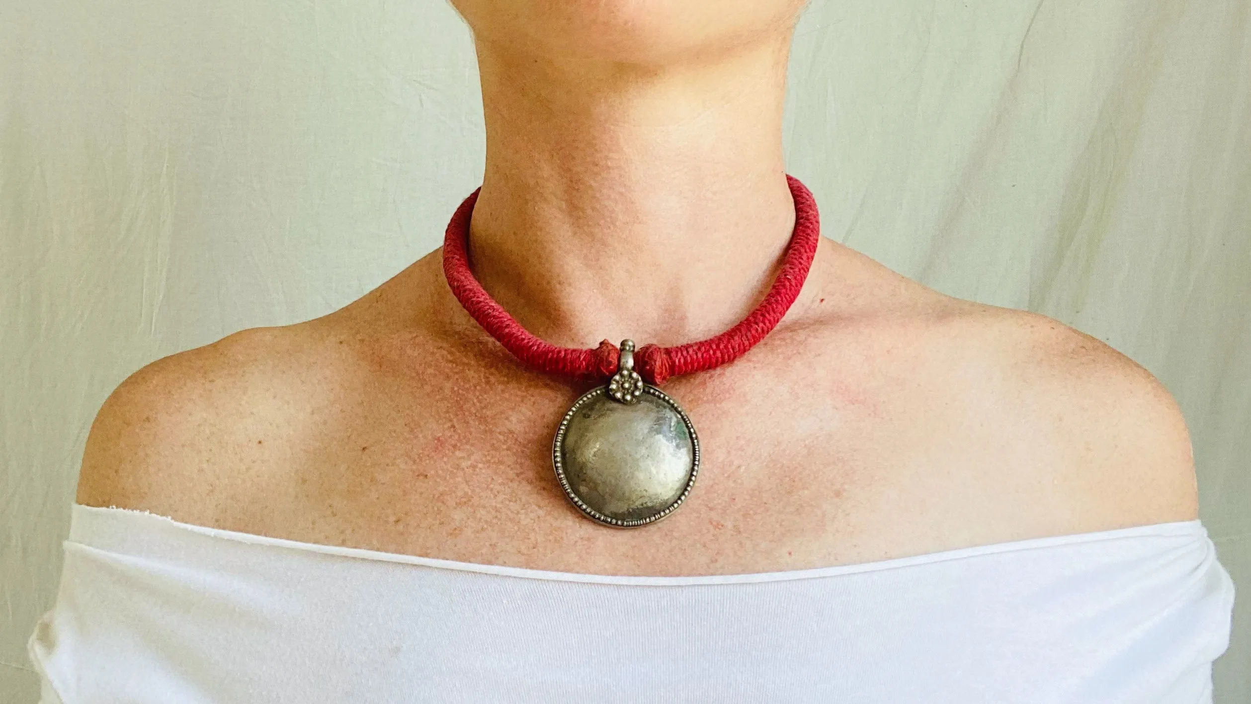 Antique Indian Silver Pendant on a Wrapped Red Cord.